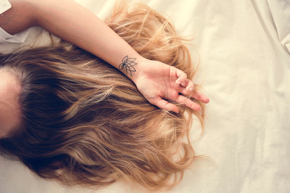 Eine Frau mit brünetten Haaren liegt auf einem Bett