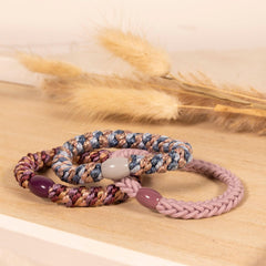 Geflochtene Haargummis auf einem Holztisch