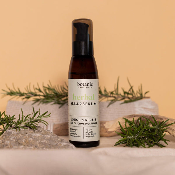 Botanic Switzerland Herbal Haarserum neben Rosmarinzweigen